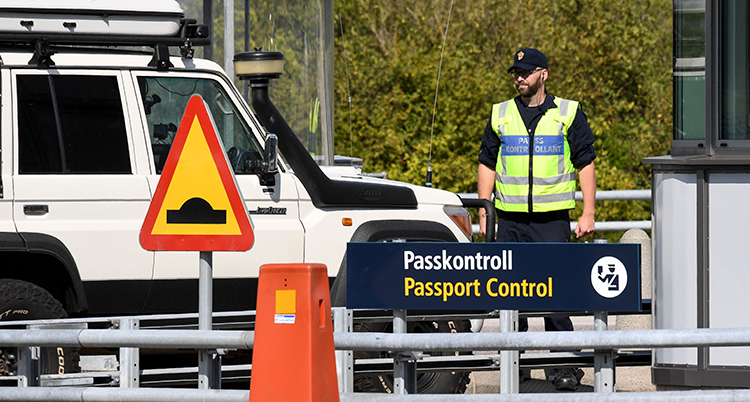 En polis i gul väst har stannat en bil vid gränsen.