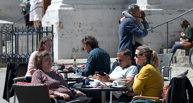 Människor sitter runt ett bord på ett kafé.
