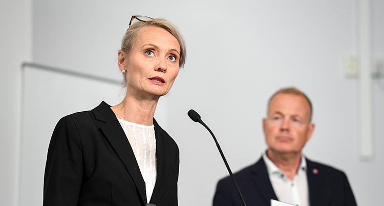 Hon har en mikrofon framför sig.