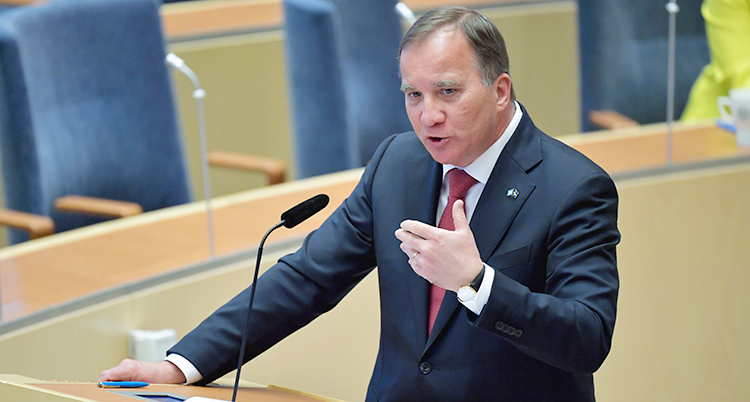 Stefan Löfven står i en talarstol. Han pratar och viftar med ena handen.