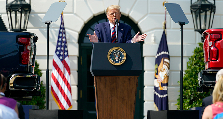 Donald Trump pratar på ett event. Han gestikulerar med armarna och har på sig blå kostym.