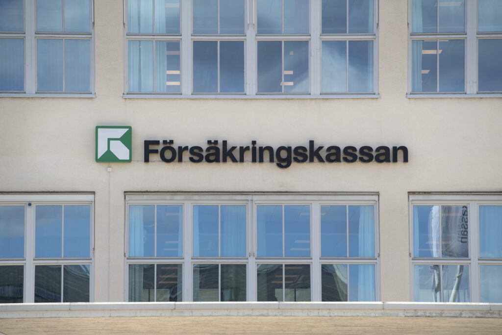 En skylt med försäkringskassans logga på en husfasad.