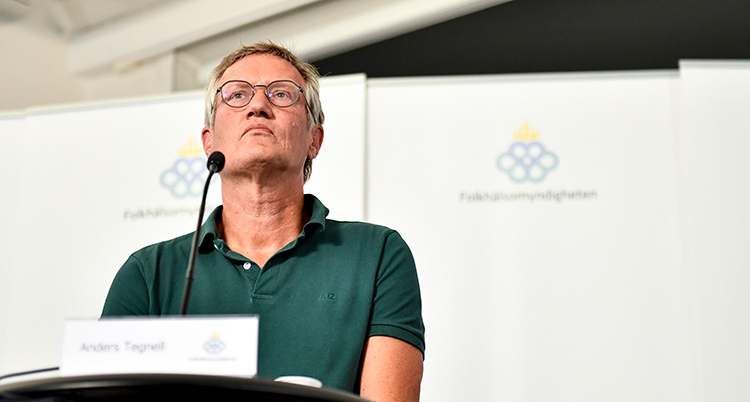Anders Tegnell i grönt fotad underifrån när han blickar ut över deltagarna på presskonferensen. Han ser allvarlig ut.