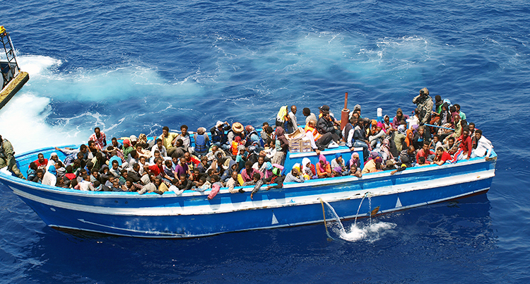 En båt är full med människor som flyr över Medelhavet till Europa.
