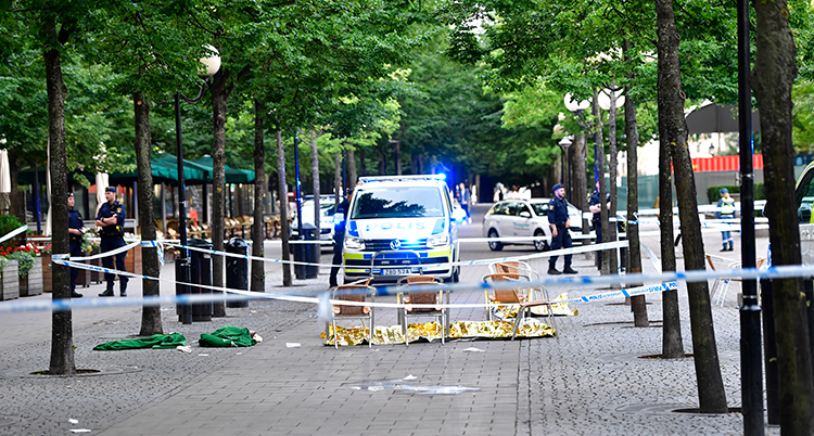 Poliser syns på gatan. Området är avspärrat med tejp.