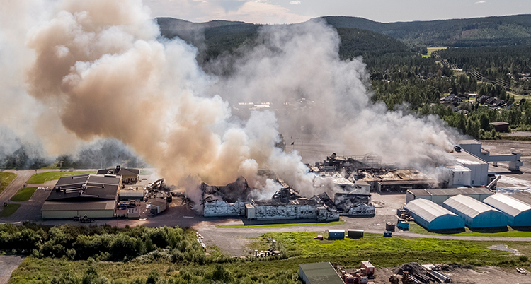 Bilden är tagen från luften ovanifrån. Det ryker massor från en stor byggnad.