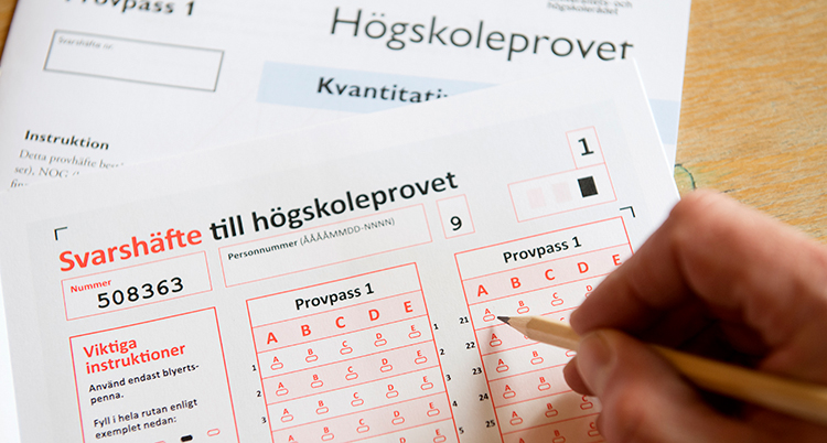 Ett högskoleprov med en hand som håller i en penna.