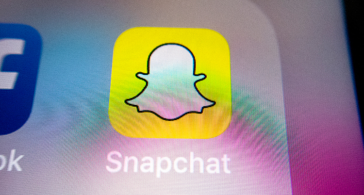 Vi ser skärmen på en mobiltelefon. Där är symbolen för Snapchat. Det är en vitt spöke på en gul bakgrund.