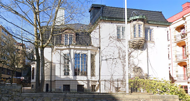 En bild på skolan. Huset är vitt med svart tak.