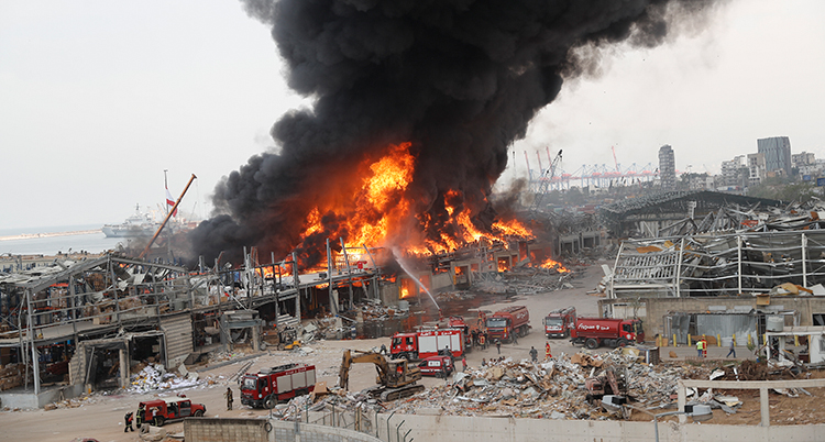 En stor brand och svart rök i hamnen i Beirut.