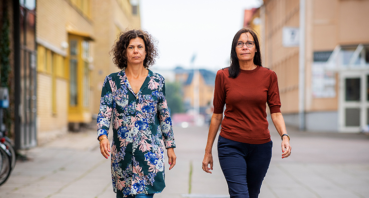 De två kvinnorna går bredvid varandra på gatan.
