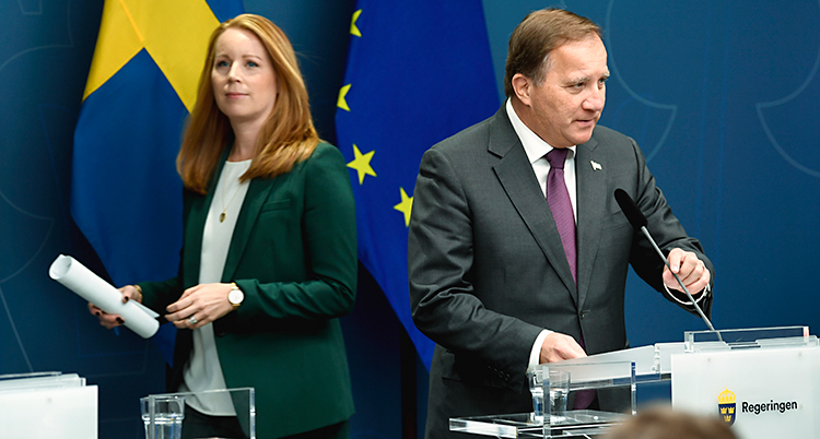 Lööf och Löfven har en presskonferens tillsammans. Lööf har en grön kavaj och Löfven har en mörk kostym. I bakgrunden finns Sveriges flagga och EUs flagga.