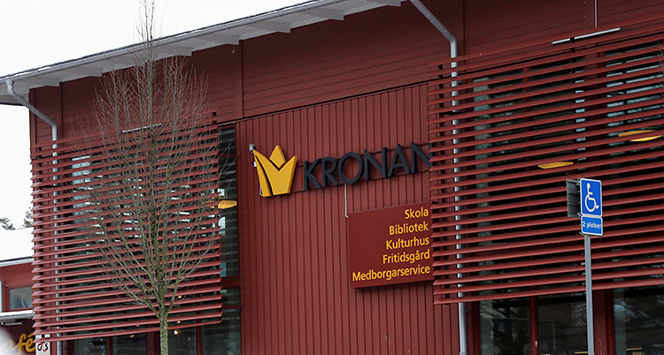 Vi ser en stor, röd byggnad. På bygganden står det Kronan.