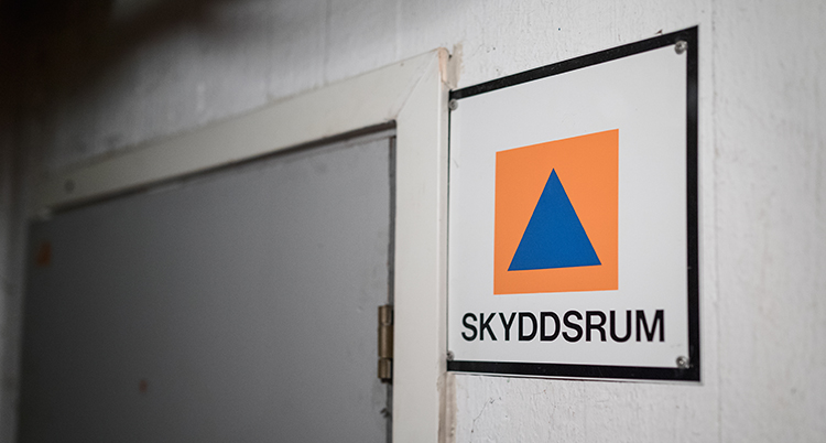 En bild på en skylt med en orange fyrkant. I den är en bli triangel.