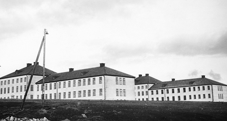 En svartvit bild på sjukhuset. Det är flera hur i vitt med svart tak. Miljön ser väldigt dyster ut. Det är inga människor på bilden.