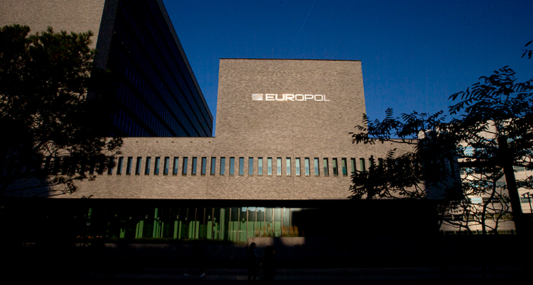 En bild på polisernas kontor. Det är en stor byggnad av sten. Himlen är blå.