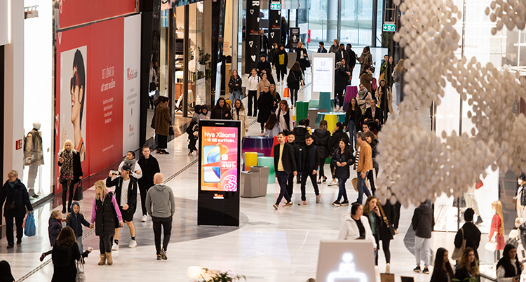 Många människor utanför butiker i ett köpcentrum