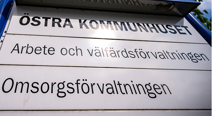 En vit skylt där det i svart står Östra kommunhuset, arbete och välfärdsförvaltningen, och omsorgsförvaltningen