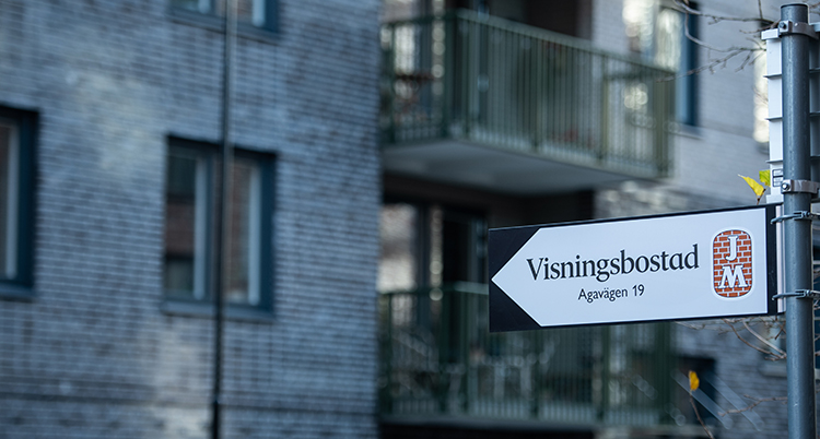 En skylt där det står Visningsbostad. I bakgrunden ett bostadshus.