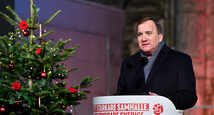 stefan löfven står vid en julgran och håller tal.