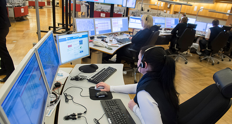 En kvinna sitter framför flera datorer.