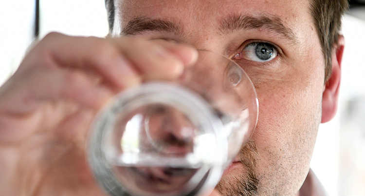 En nära bild på hans ansikte när han dricker ett glas vatten.