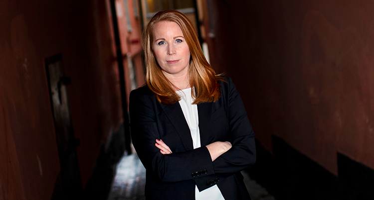 Lööf står med armarna i kors över bröstet. Hon tittar in i kameran och ser bestämd ut. Hon har svart kavaj och vit blus.
