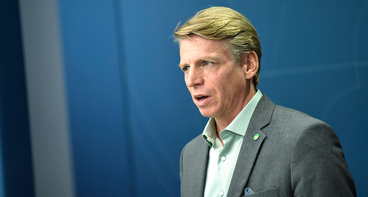 Bolund från sidan. Bara överkroppen syns. Han pratar. På hans grå kavaj sitter miljöpartiets märke.