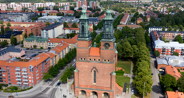 En översiktsvy över Eskilstuna, med Klosters kyrka i förgrunden och många hus bakom.