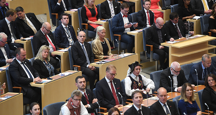 Politiker i riksdagen sitter i sina bänkar