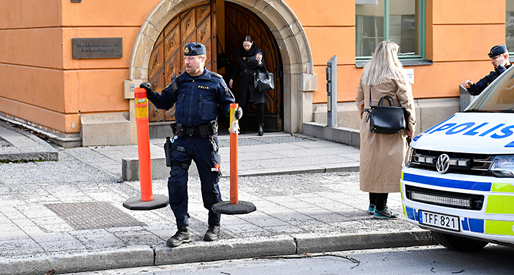 En polis spärrar av framför domstolen.