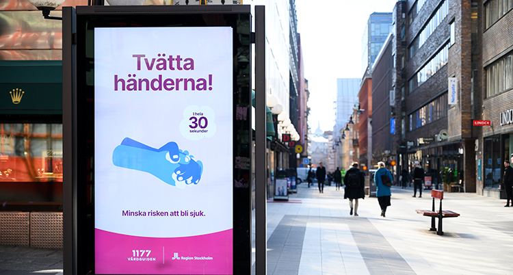 En nästan tom gåtata med en stor skylt. På den står det tvätta händerna