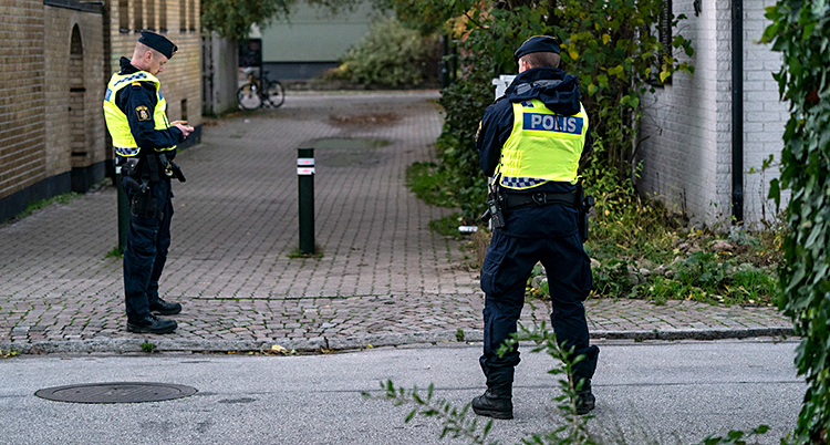 En gata i Malmö. Två poliser står på gatan.