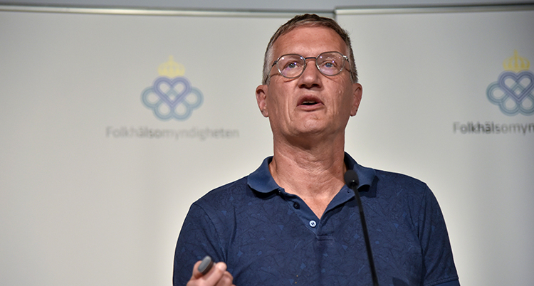 Han ser allvarlig ut och talar i en mikrofon.