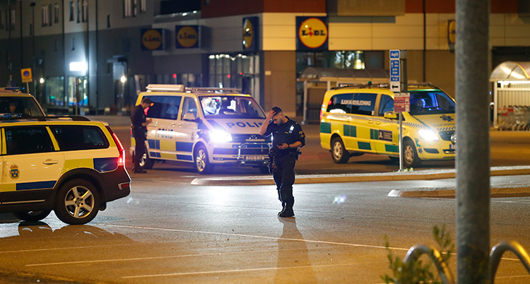 Poliser arbetar på platsen i Huddinge där en man blev skjuten.