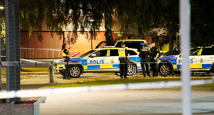 en avspärrad plats. Poliser står bakom banden.