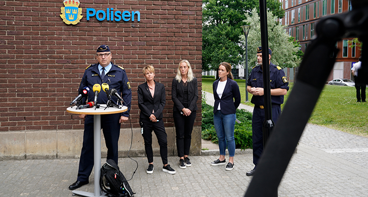 poliser pratar till journalisterna.