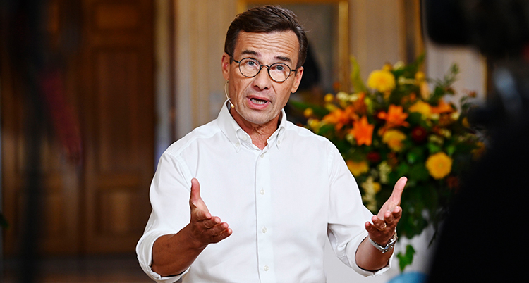 Han har vit skjorta. Han lyfter sina händer.