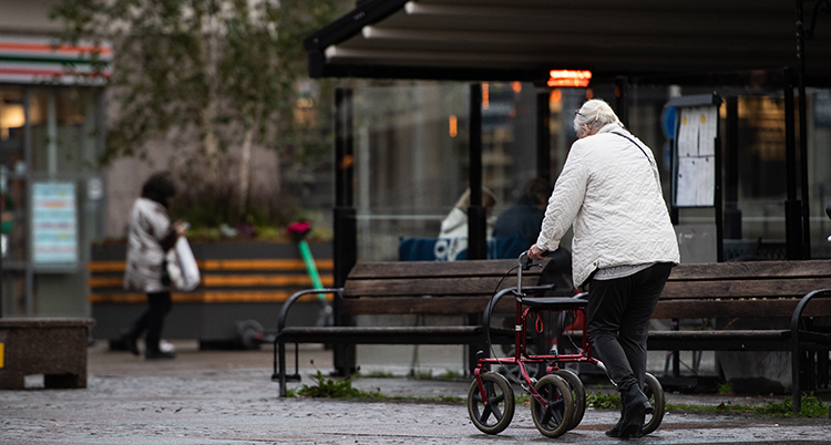 En kvinna går med rollator.