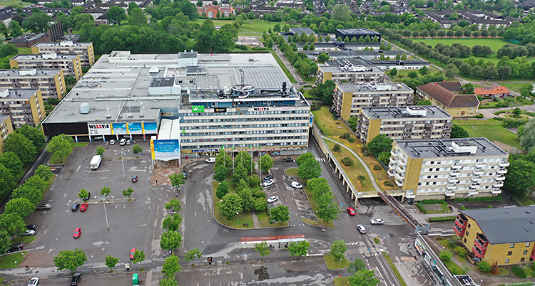 En bild på området Skäggetorp. Bilden är tagen från luften. Man ser ett köpcentrum och stora hus med lägenheter. Och träd och parker.