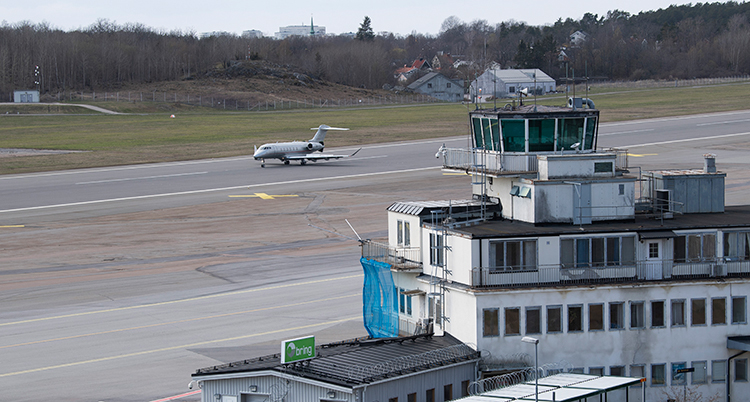 Ett flyg på en startbana. Ett flygtorn syns också.