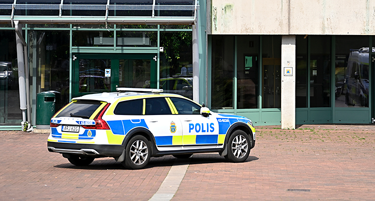 En polisbil står parkerad utanför en skola.
