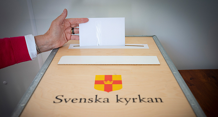 En arm sticker fram. Den lägger ett kuvert i en låda.