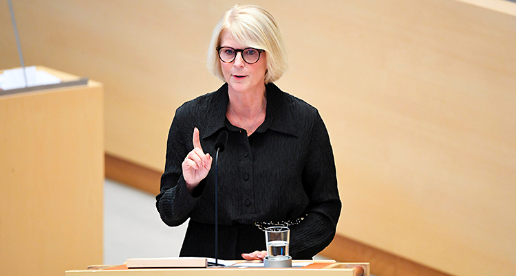 Hon står och pratar i riksdagen.
