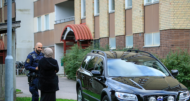 De står framför ett hus.