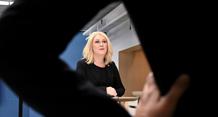Hon syns på avstånd. Hon har ljus hår och en svart överdel.