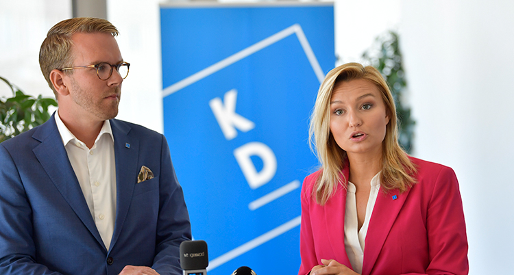 Politikerna står bredvid varandra. Ebab Busch talar och Andreas Carlsson tittar på.