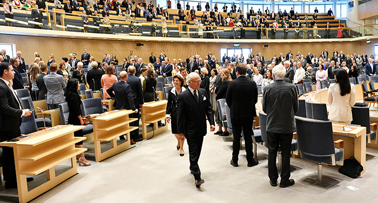 Riksdagen stora sal fylld med människor. Kungen gåröver golvet.