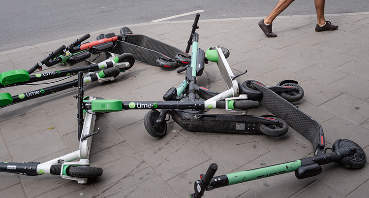 Sparkcyklar ligger på en trottoar