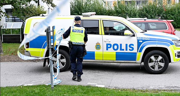 En polisbil och en polis syns. Platsen är avspärrad med tejp.